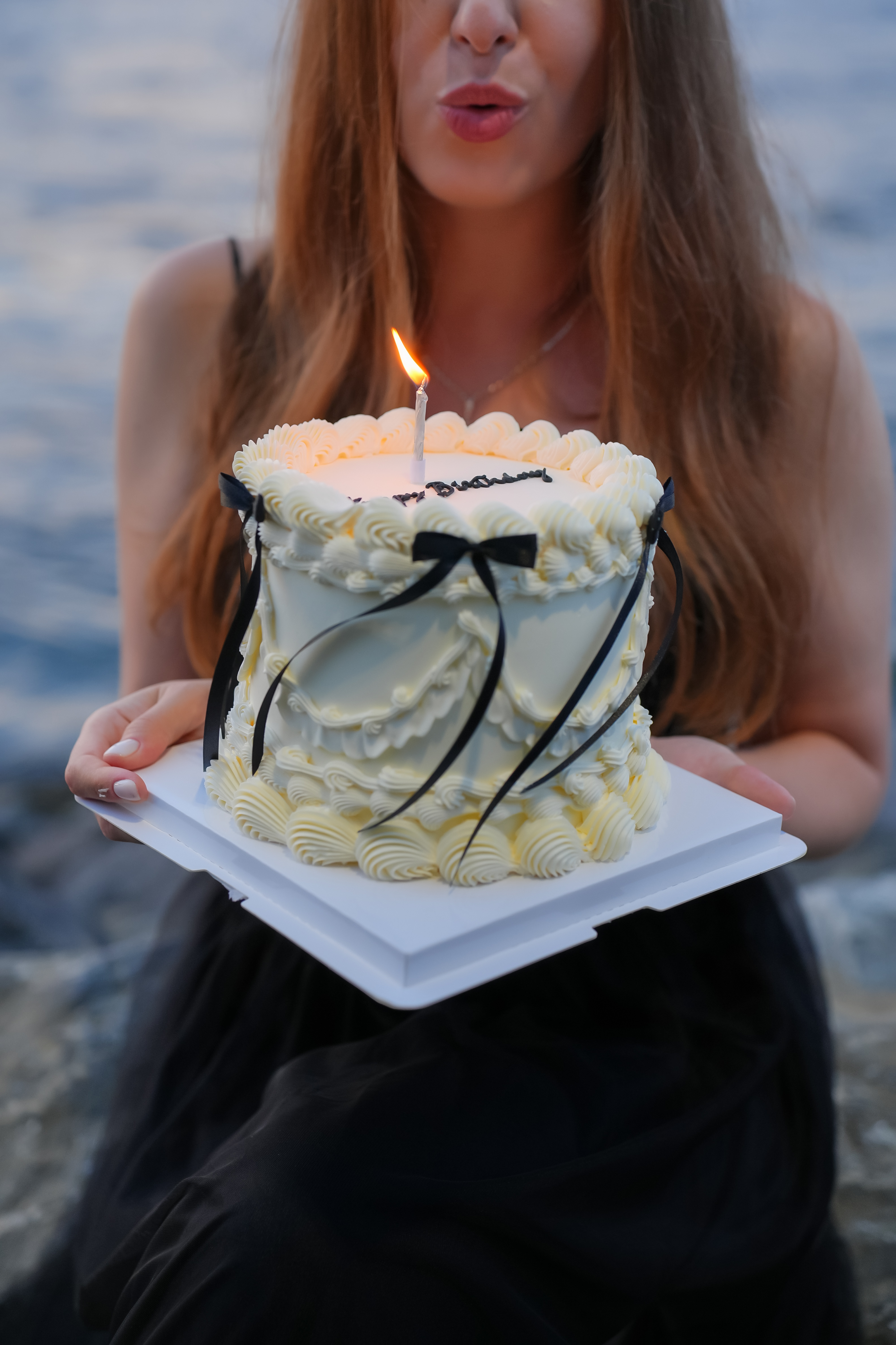 Custom vintage cake with candle by the waterfront